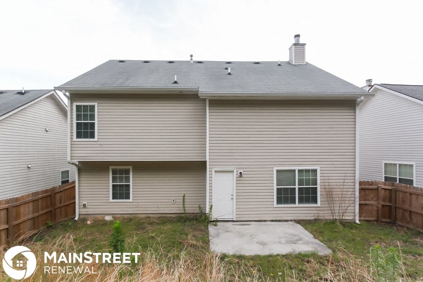 the back of a house with a garage and a yard