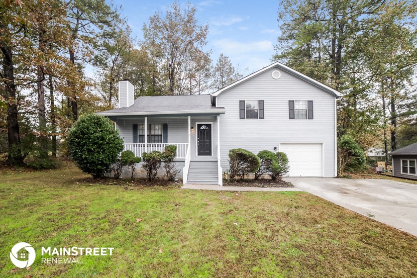 a white house with a lawn and a driveway