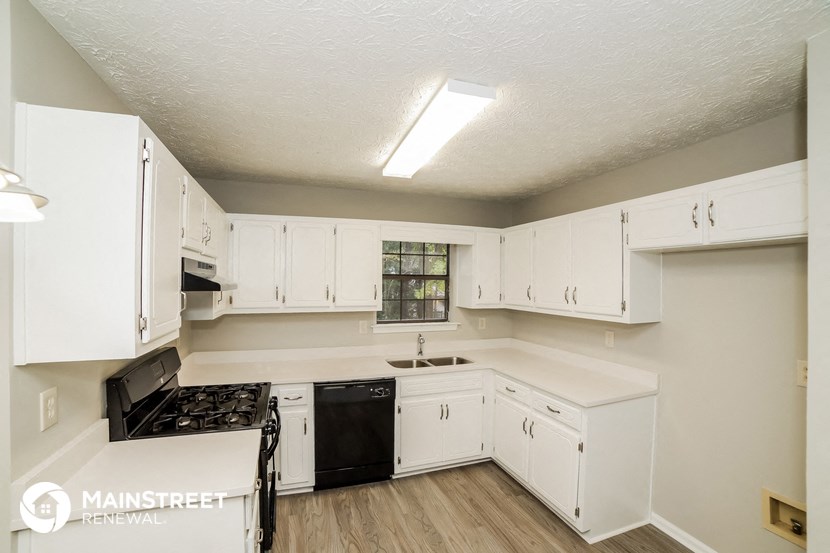 a kitchen with white cabinets and a stove and a sink
