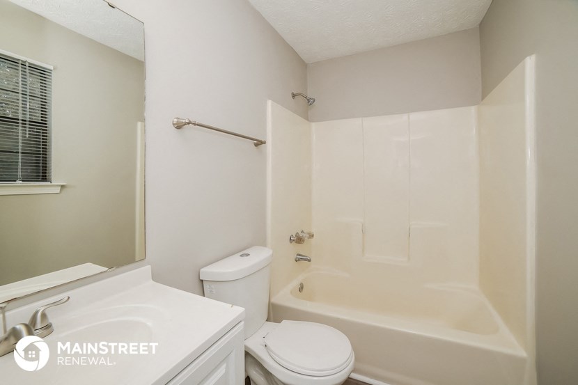 a bathroom with a tub and a sink and a toilet