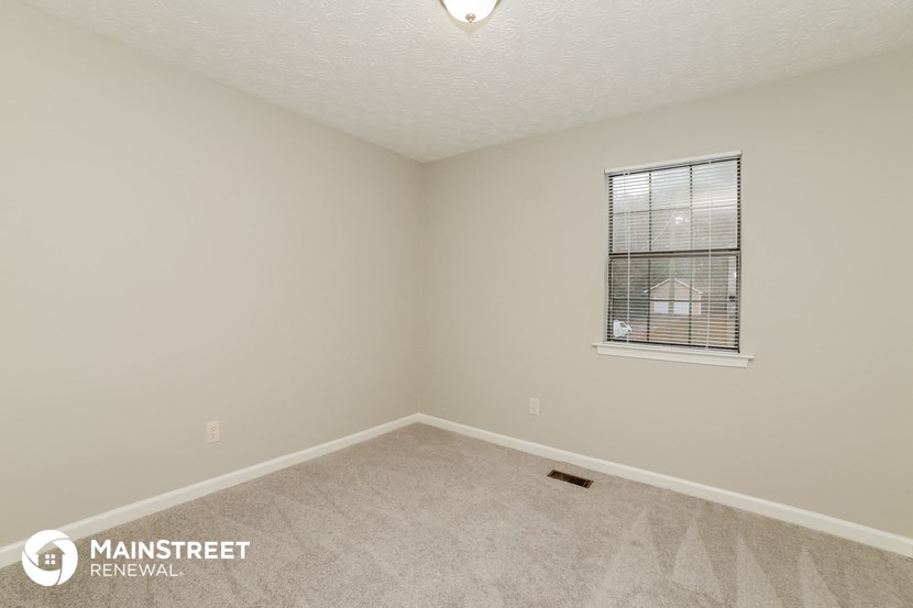 the upstairs bedroom with carpet and a window