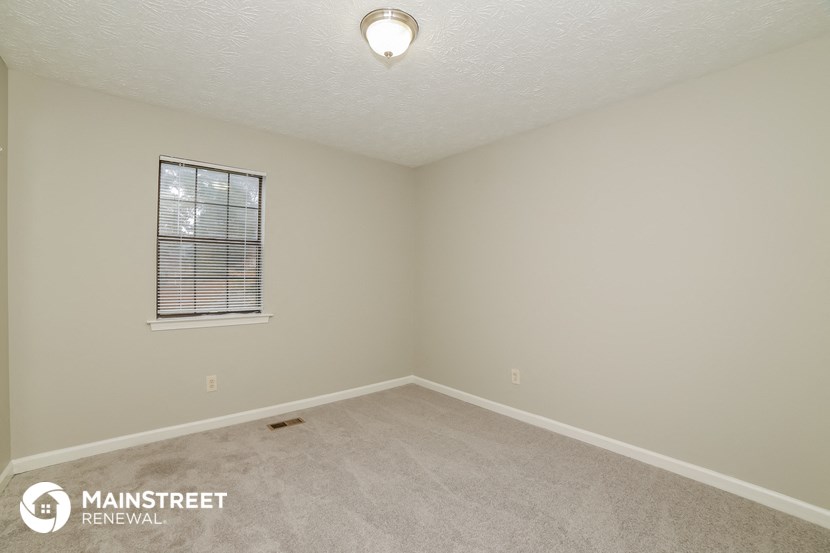 the upstairs bedroom with carpet and a window