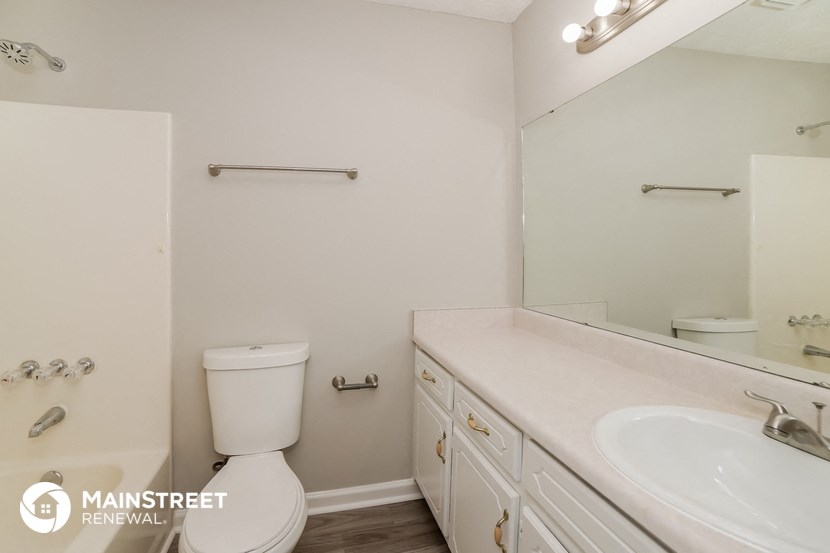 a bathroom with a toilet and a sink and a mirror