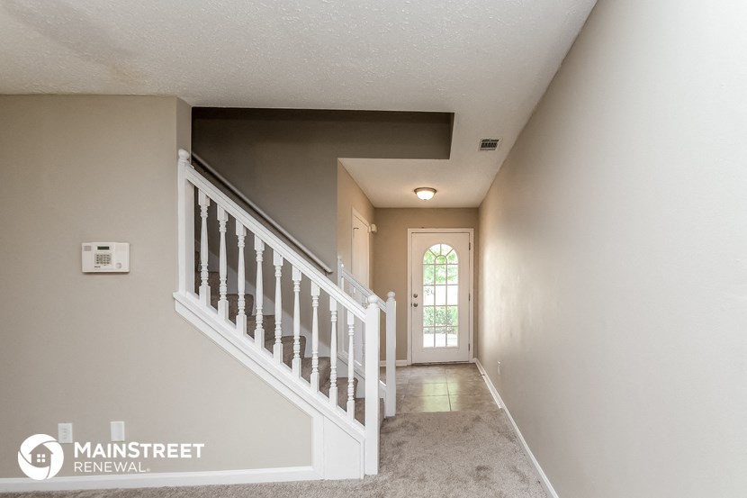 theoyer of a home with a staircase and a door to a hallway