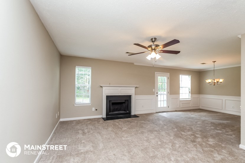 a living room with a fireplace and a ceiling fan