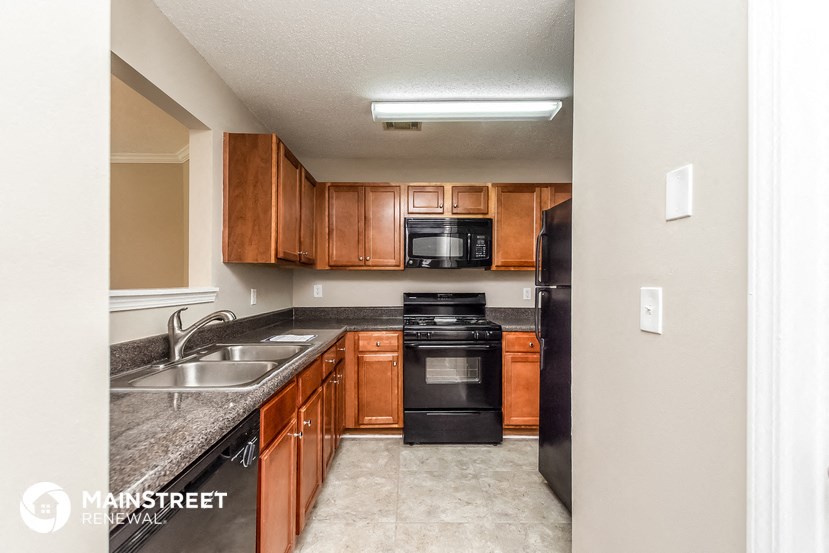 a kitchen with wooden cabinets and black appliances