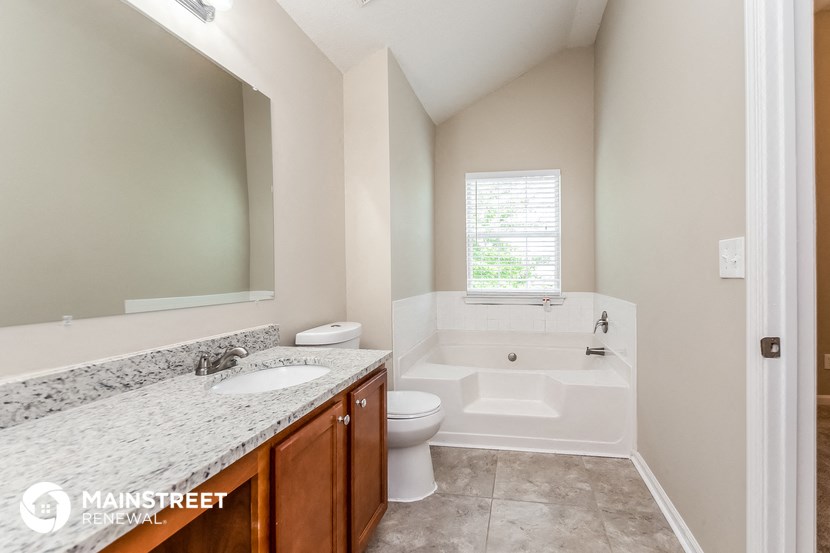 a bathroom with a tub and a sink and a toilet