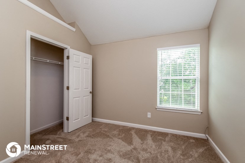 a bedroom with a closet and a window and a door