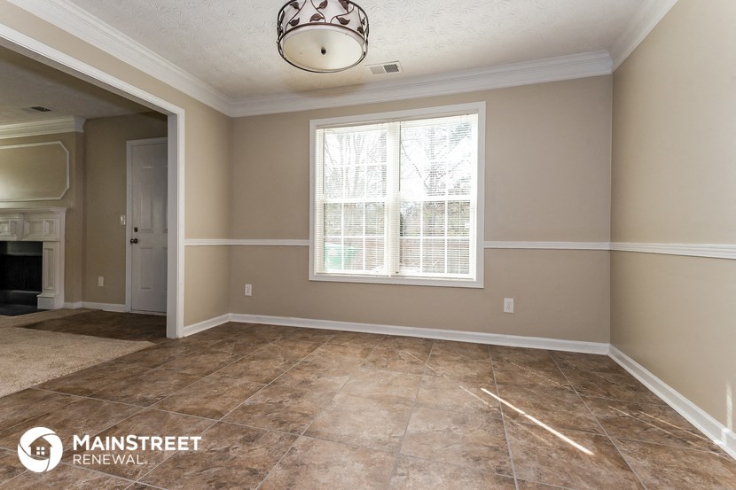 an empty living room with a fireplace and a window