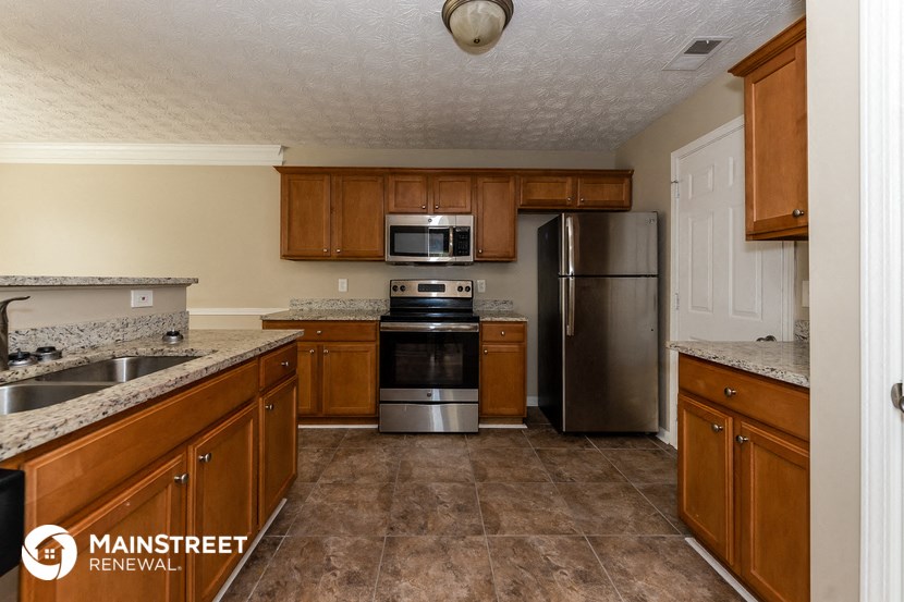 a kitchen with wooden cabinets and stainless steel appliances