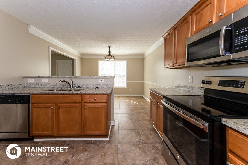 a kitchen with granite counter tops and wooden cabinets