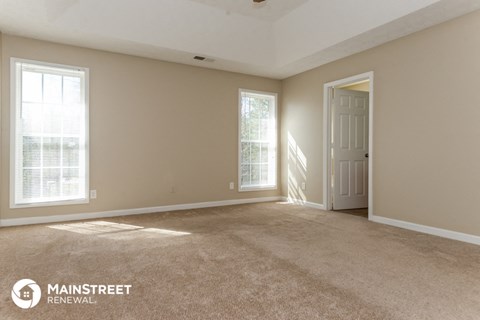 the living room of a home with carpet and a door