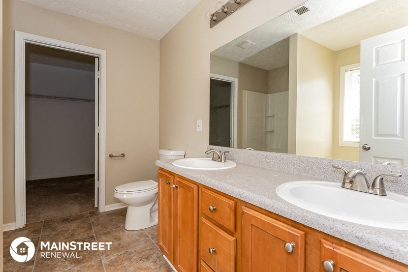 a bathroom with two sinks and a toilet and a mirror