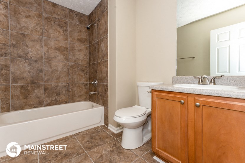 a bathroom with a toilet and a tub and a sink