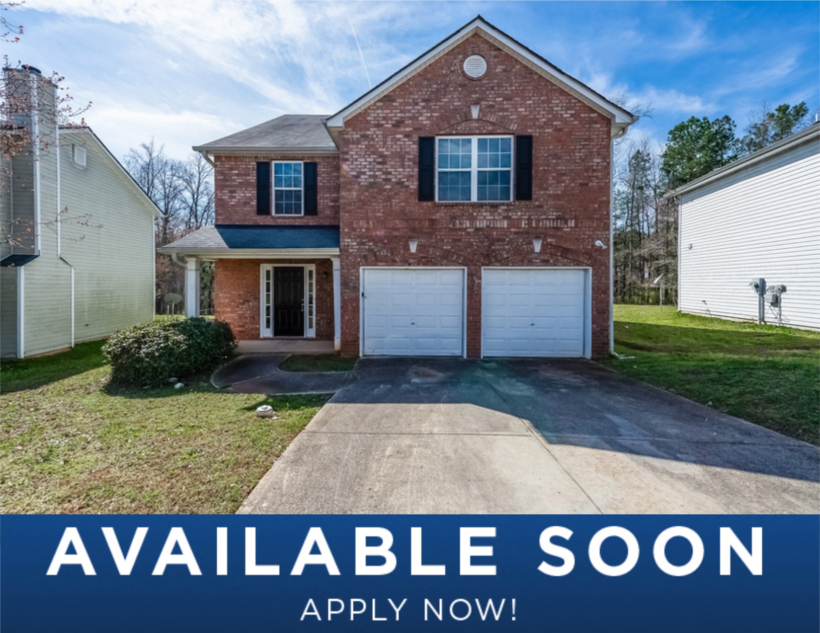 a updated brick house with two garage doors and a lawn