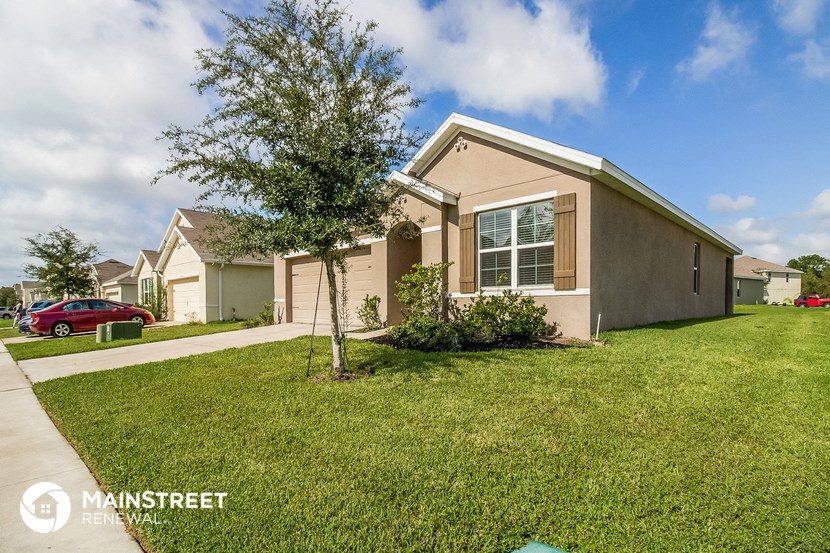 a home with a lawn and a tree in front of it