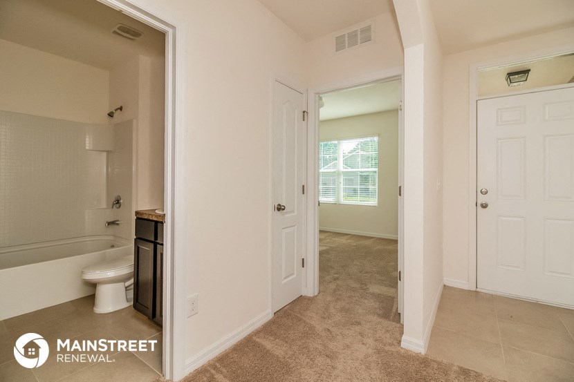 a bathroom and a hallway with a toilet and a sink