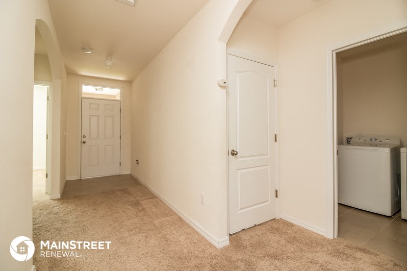 a hallway with a closet and a door to a laundry room