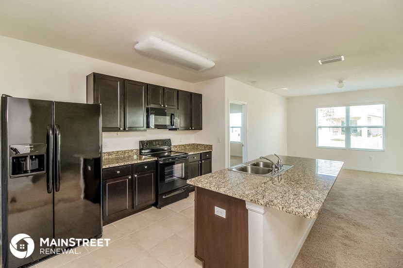 a large kitchen with stainless steel appliances and granite counter tops