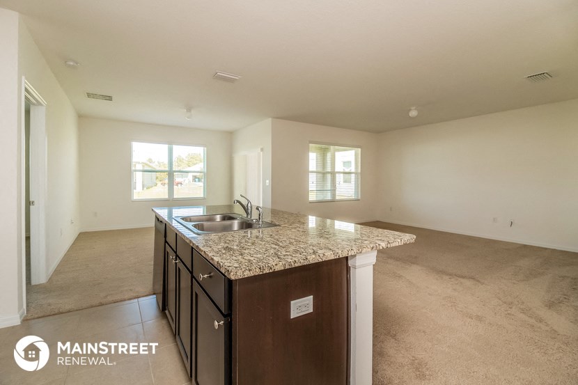an empty kitchen with a granite counter top and a sink