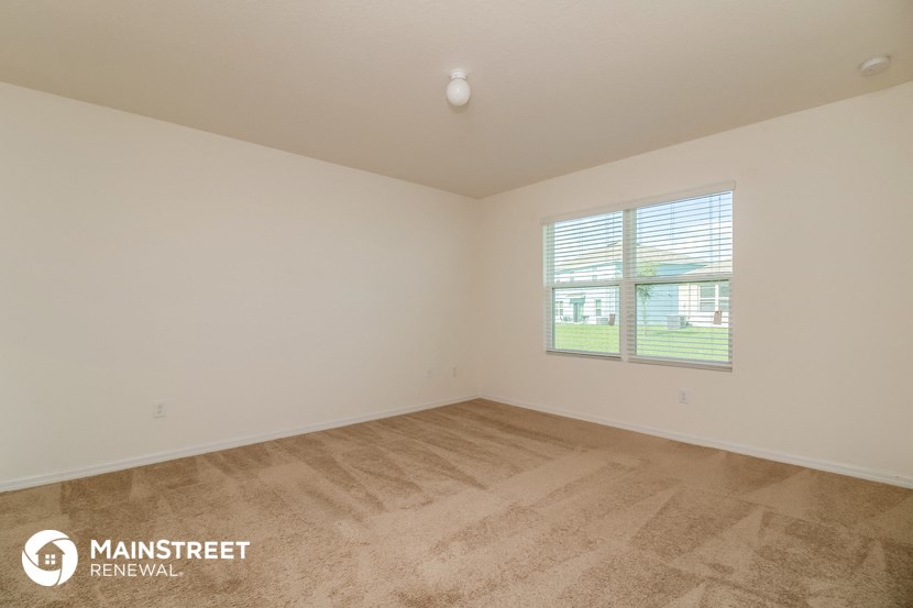 the living room of a home with a carpeted floor and a window