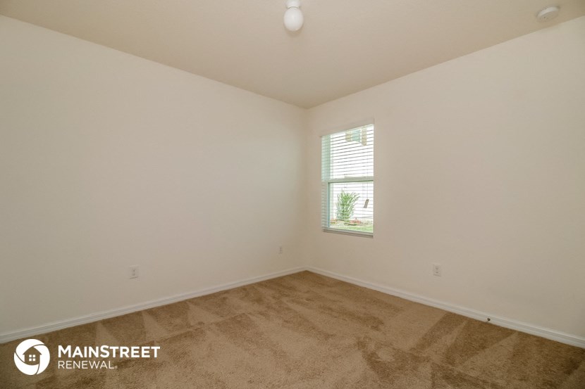 the living room of a home with carpet and a window