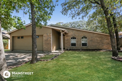 a house with a lawn and two trees