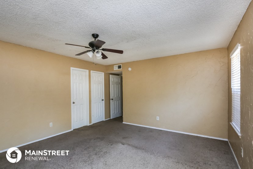 the spacious living room of this manufactured home has a ceiling fan