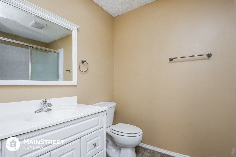a bathroom with a toilet and a sink and a mirror