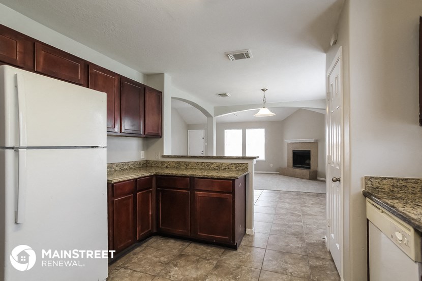 a kitchen with wood cabinets and a white refrigerator