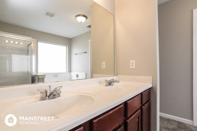 the master bathroom has a large mirror and a large sink