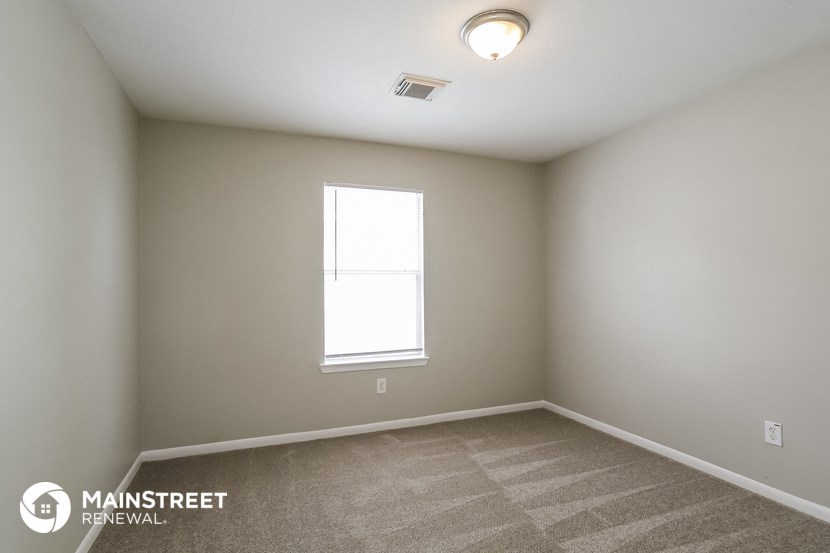 the interior of a bedroom with carpet and a window
