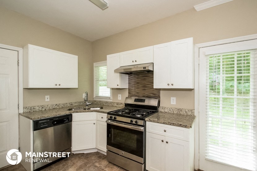 a kitchen with white cabinets and stainless steel appliances and granite counter tops