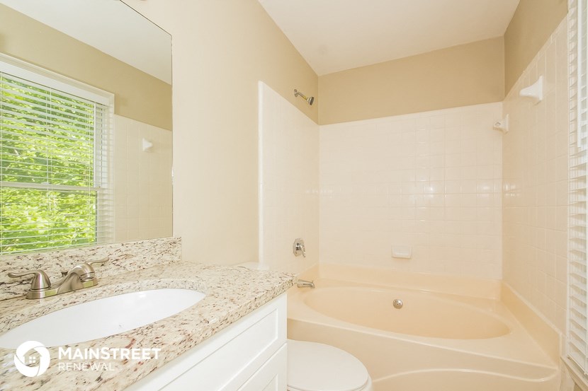 a bathroom with a tub and a sink and a toilet