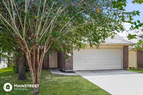 a home with a white garage door and a tree