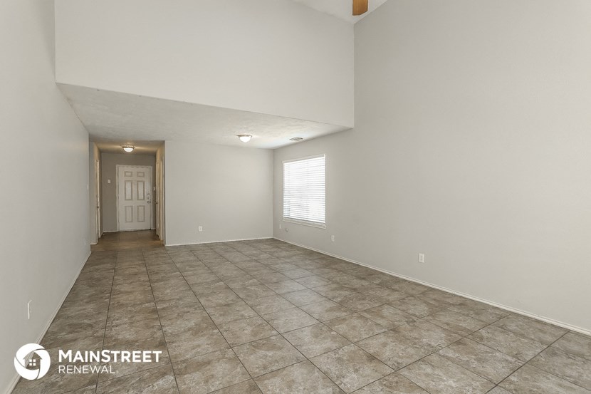 the spacious living room with tile flooring and white walls