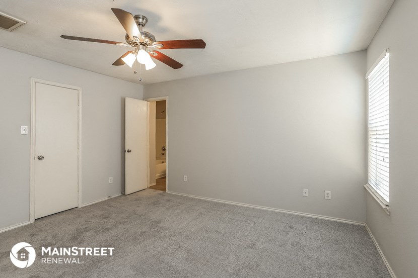 the living room of an empty house with a ceiling fan