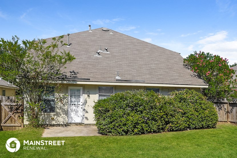a house with a gray roof and a green lawn