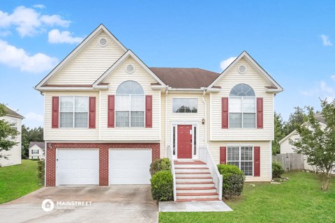 a white house with red shutters and a red door