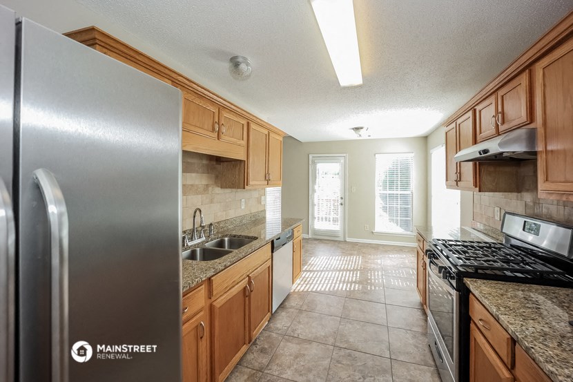 a kitchen with wood cabinets and stainless steel appliances and a sink