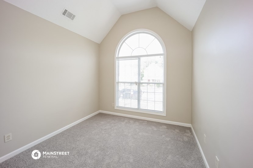 an empty room with a large arched window