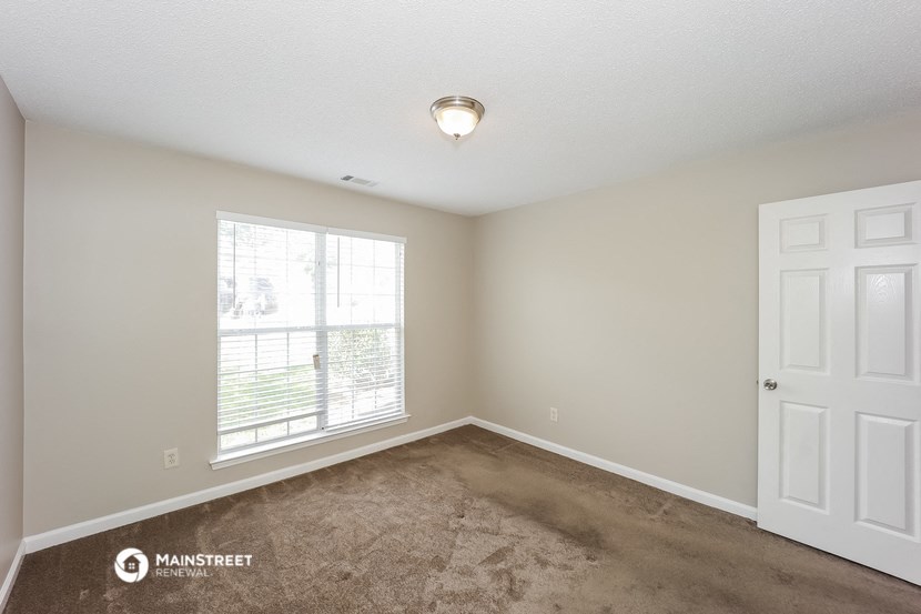 an empty room with carpet and a window
