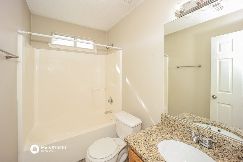 a bathroom with a shower toilet and sink and a mirror