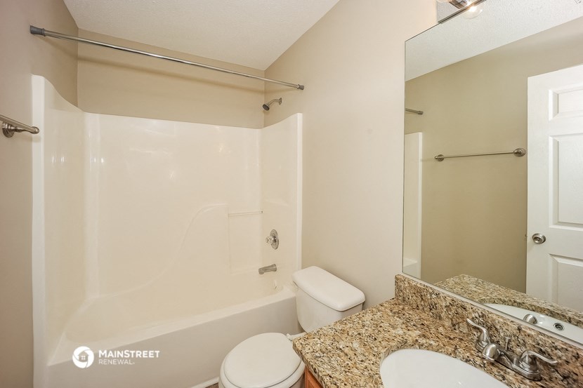 a bathroom with a tub and a sink and a mirror