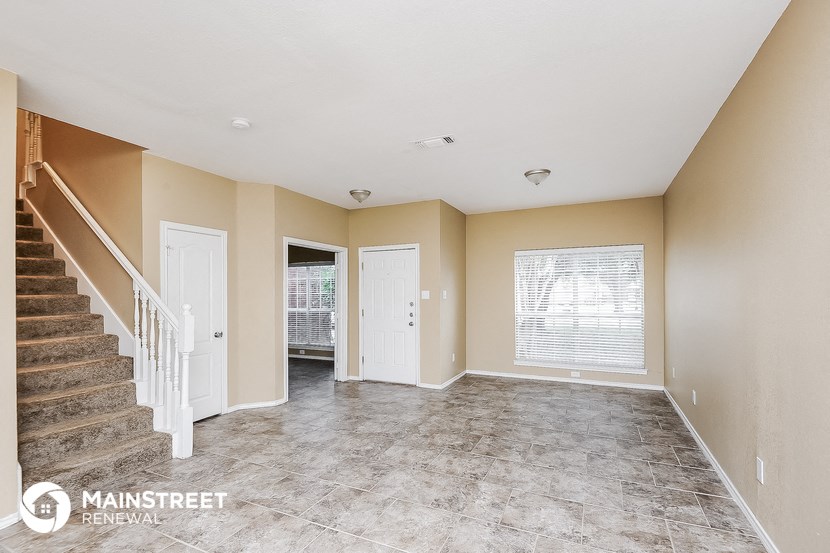 the living room and entryway of an empty house