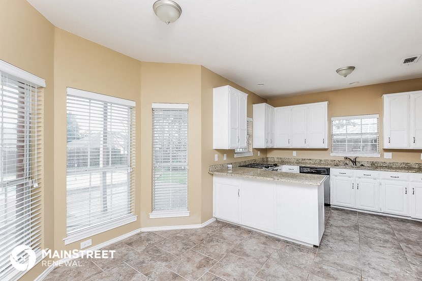a kitchen with white cabinets and a counter top