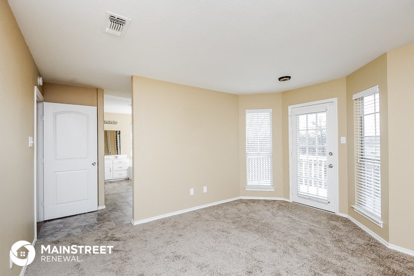 a living room with a white door and a carpeted floor