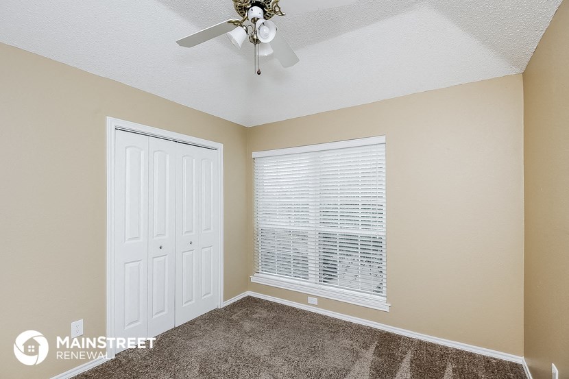 the master bedroom has a ceiling fan and a closet