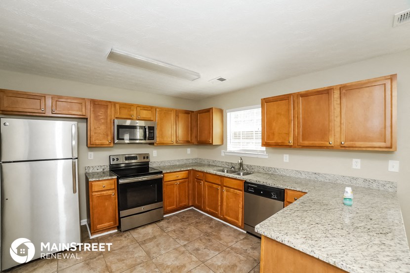 a kitchen with wooden cabinets and stainless steel appliances