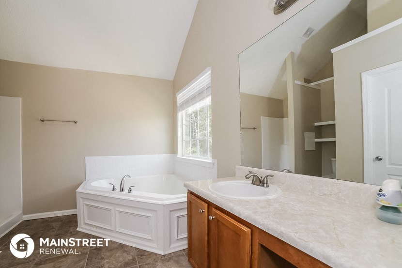 a bathroom with a tub and a sink and a mirror